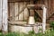 Wooden plank shelter for the water well site with a bucket