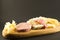 wooden plate with cheeses and cold cuts like gruyere, mortadella, Roquefort and prosciutto