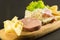 wooden plate with cheeses and cold cuts like gruyere, mortadella, Roquefort and prosciutto