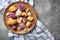 Wooden plate with colorful cauliflowers on grey table