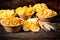 Wooden plates with snacks near wheat, scattered chips on dark wooden desk