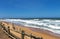 Wooden Pole Barrier on Beachfront Against Coastal Landscape