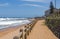 Wooden Pole Barrier on Beachfront Against Coastal Landscape