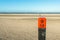 Wooden pole on an empty beach at the North Sea from close