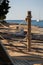 Wooden pole with ropes at the beach with view to sea and yacht. Calm atmosphere at the evening resort.