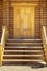 Wooden porch, door and staircase in a log frame house. The ancient technology of building a Russian log hut and churches