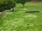 Wooden post fence in a green field with abandoned black tires