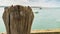 Wooden post with ships in the background, Wales, UK