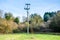 A wooden powerline pole with the powerline coming into the ground and lines to other poles .