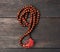 Wooden prayer rosary on a brown wooden table, top view