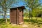 Wooden professionally repaired outhouse in a green park