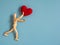 Wooden puppet jumping from the wooden floor in the air to catch the red heart floating in the sky. Wooden puppet try to jump to ca