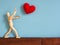 Wooden puppet lift hands on the air for lets not get hit from the red heart fall on the head. A Wooden puppet throws red hearts