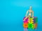 Wooden puppet sitting on cube plastic colorful number on blue background. Concept of education mathematics or calculation. copy sp