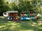 Wooden rack with colorful kayaks and green grass