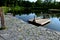 A wooden raft is tied to a taut rope. self-service ferry across the river, pond. People get on and pull their hands to the other b