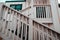 wooden railing with nice vintage white bars going up to cozy house with dark square window in lonely quiet village, west