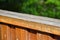 Wooden railing on the terrace outside. Detail on wood. Green landscape in the background