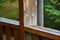 Wooden railing on the terrace outside. Detail on wood. Green landscape in the background