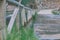 Wooden railings of an old partially sunken wooden bridge over a tranquil river