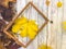 Wooden rectangular picture frame and yellow autumn leaves, maple on the background of wooden boards. The background. Texture