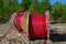 Wooden Reel with High Voltage Red Cable in Forest: Ready for Underground Power Line Installation