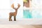 Wooden reindeer on swimming pool edge over blurred blue water background