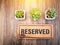 Wooden reserved sign on top of a wooden table in a restaurant, R