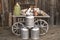 Wooden retro cart with wateringcans logs and wooden background.