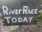 Wooden river race sign on wood stake and rocks