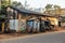 Wooden roadside shacks attached to a rustic structure with tin roofs on a quiet