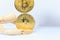 Wooden robot model stops falling Bitcoin cryptocurrency token on white background. Investment, Currency Uncertainty, Risk and