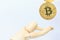 Wooden robot model stops falling Bitcoin cryptocurrency token on white background. Investment, Currency Uncertainty, Risk and