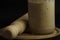 Wooden rolling pin and sourdough starter in a glass jar on black background