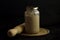 Wooden rolling pin and sourdough starter in a glass jar isolated on black background