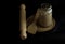 Wooden rolling pin with spoon and sourdough starter in a glass jar isolated on black background