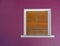 Wooden rolling shutters window on colorful violet painted wall