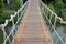 Wooden rope suspension bridge for walk crossing river