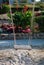 Wooden rope swing above the sand against the flowerbed