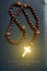 Wooden rosary in the aureole of the divine of Divine Rays on a b