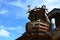 Wooden round balcony with support columns made of tree trunks, installed as lookout tower on side of stables