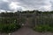 Wooden round rail garden fence in the cloudy day.