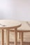 Wooden round tables in white minimal living room interior. Real photo