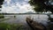 Wooden row boat anchored, floating on polluted lake