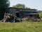 Wooden rural wood-burning barn on a green glade in summer in sun