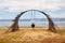 Wooden rustic swing on the beach of Olkhon island. A young girl is sitting on a swing