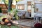 Wooden RV house porch with garden furniture. Decor summer yard. Campsite in garden. Interior cozy yard campsite with green plants