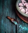 Wooden scoop with blue sea salt and bowl with water and flowers