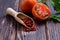 Wooden scoop with tomato powder on wooden surface