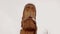 wooden sculpture of a bearded man with closed eyes covered in snow